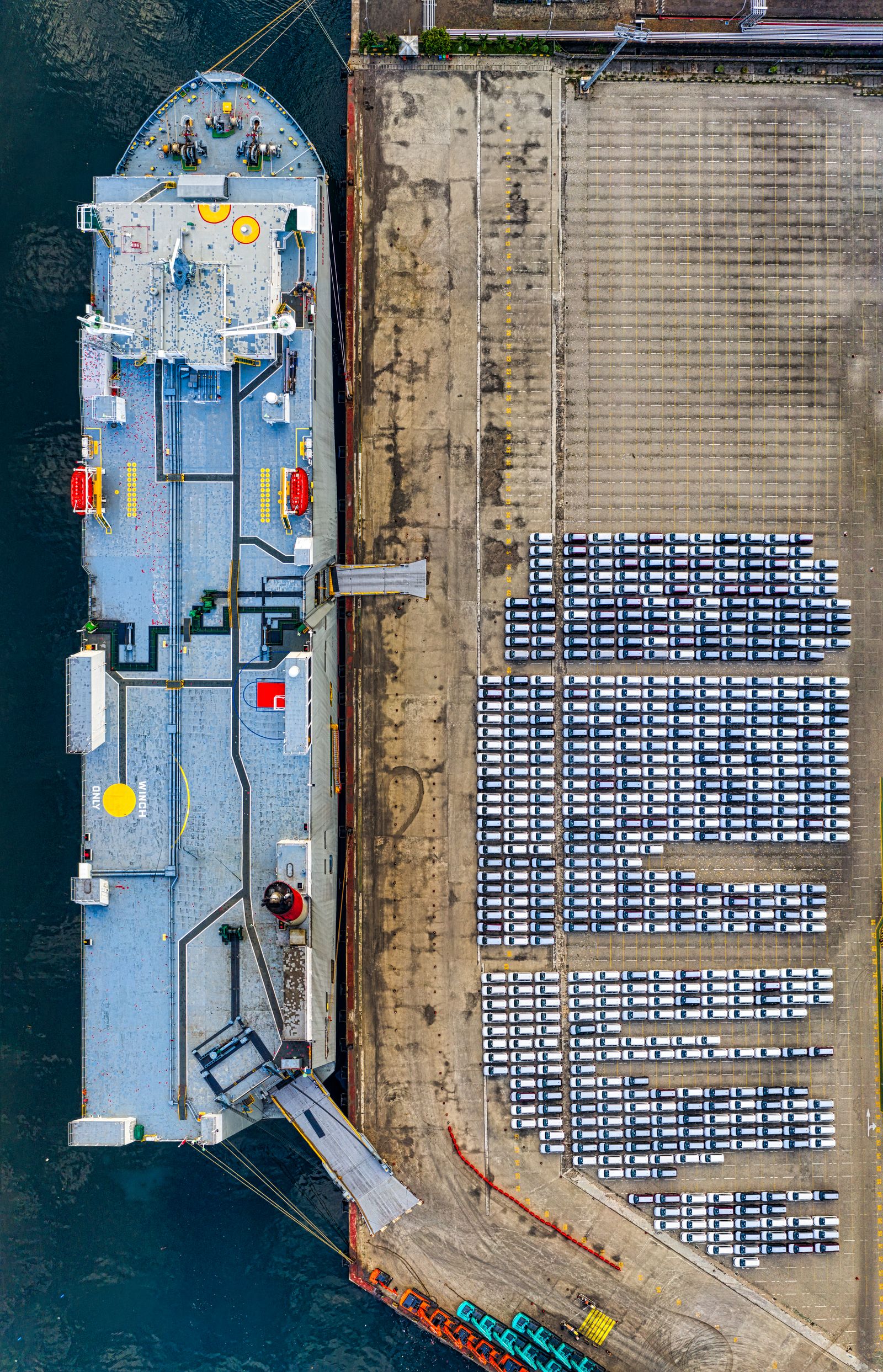 Aerial view of a vehicle export yard beside a quay